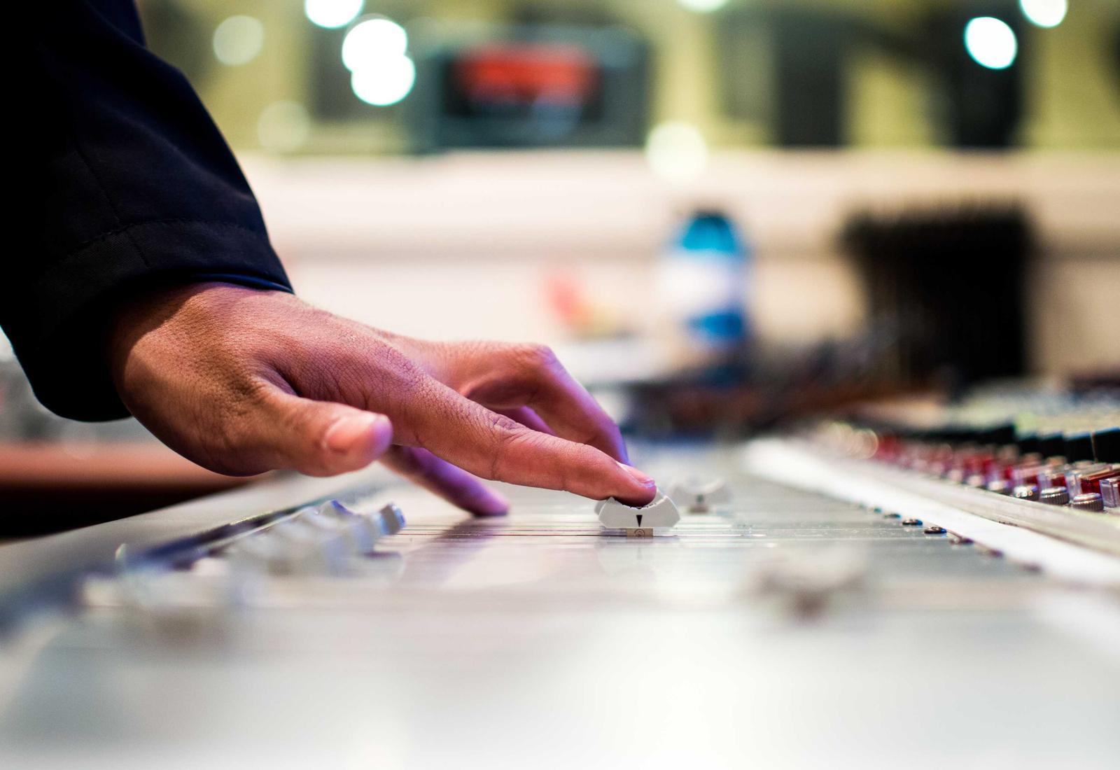 Hands adjusting controls on an operations console